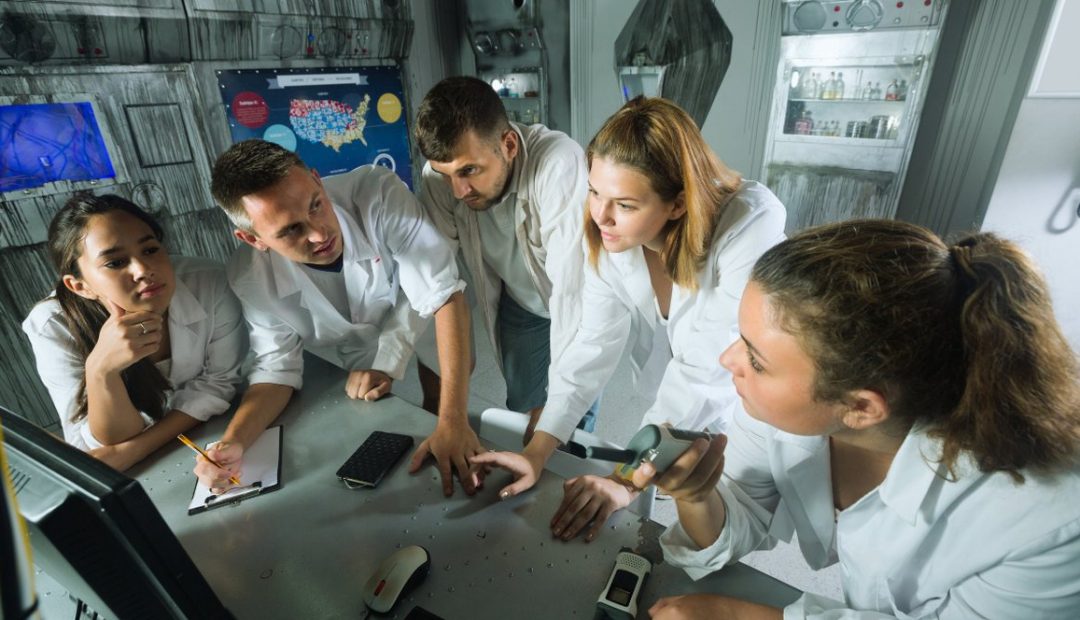 Groupe de joueurs concentres resolvant des enigmes dans une salle d'escape game